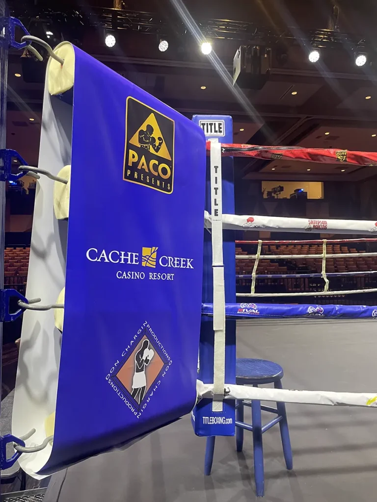 Boxing ring corner with branded banners for Paco Presents and Cache Creek Casino Resort.